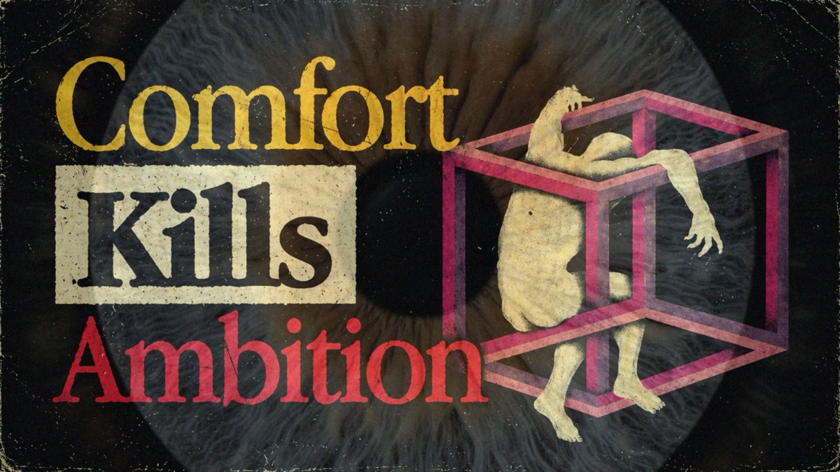 A pale figure folded inside a pink wireframe cube against an iris, beside the words Comfort Kills Ambition.